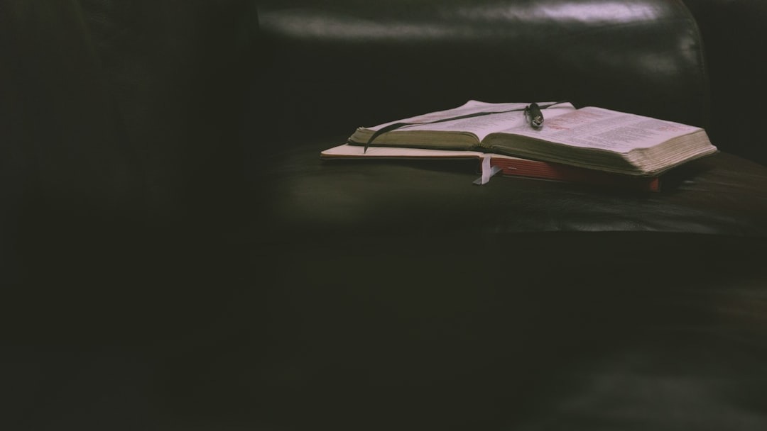 An open book with a pen resting on its pages.
